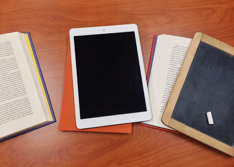 Books, chalk slate, and a tablet computer on the table